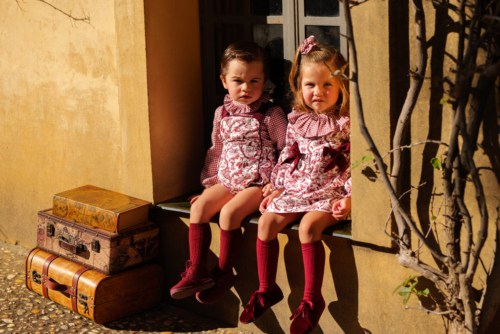 Conjunto vestido y braguita bebé burdeos foto lifestyle exterior ambiente cálido Charanga