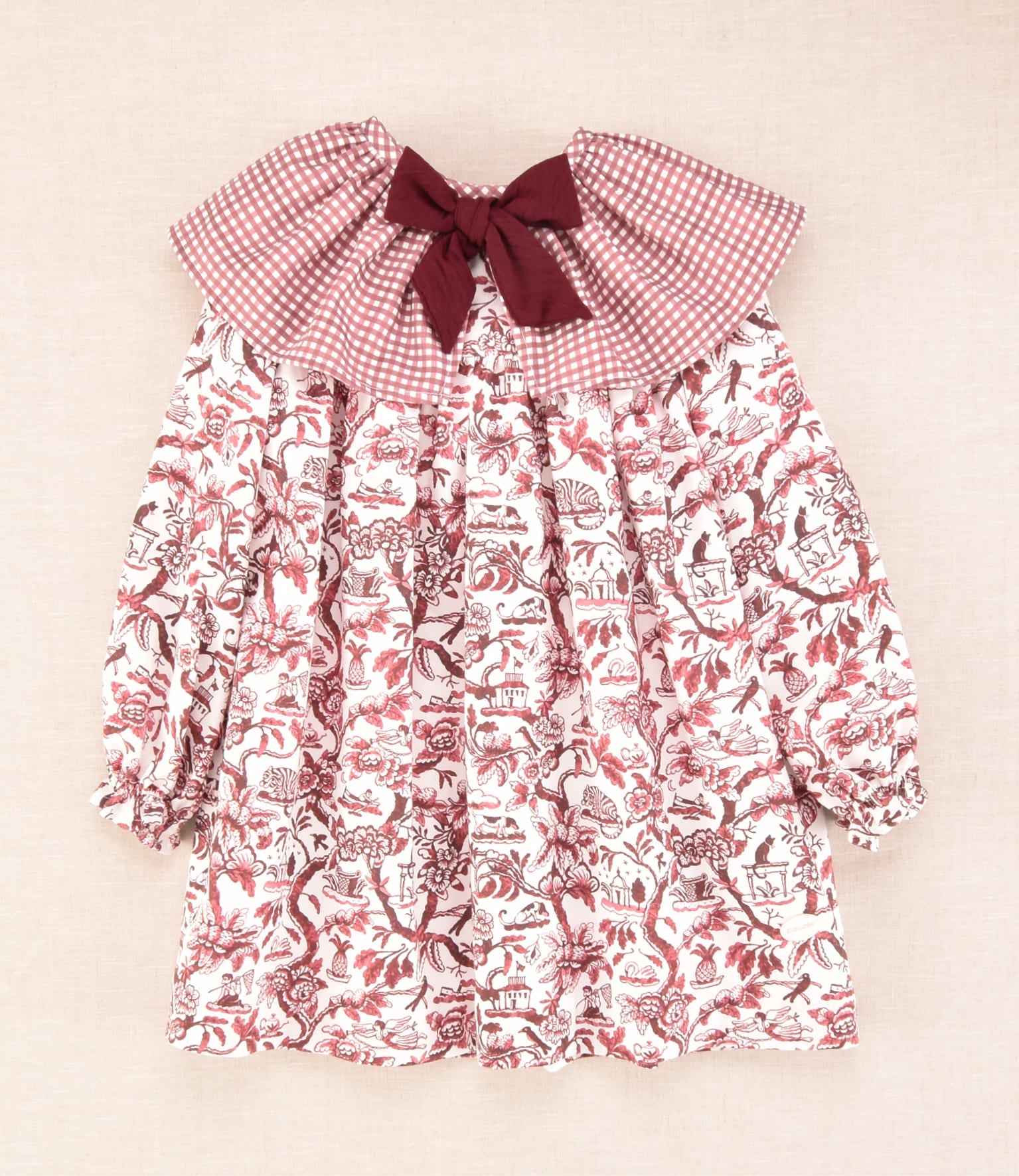 Vestido infantil de manga larga con cuello bebé de cuadros y estampado floral en burdeos, colección Cocote x Charanga