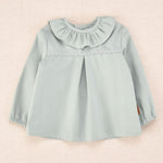 Blusa de bebé verde agua con cuello volante y detalle ondulado, colección Cocote x Charanga