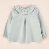 Blusa de bebé verde agua con cuello volante y detalle ondulado, colección Cocote x Charanga