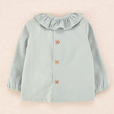 Espalda de blusa de bebé verde agua con botones de madera, colección Cocote x Charanga