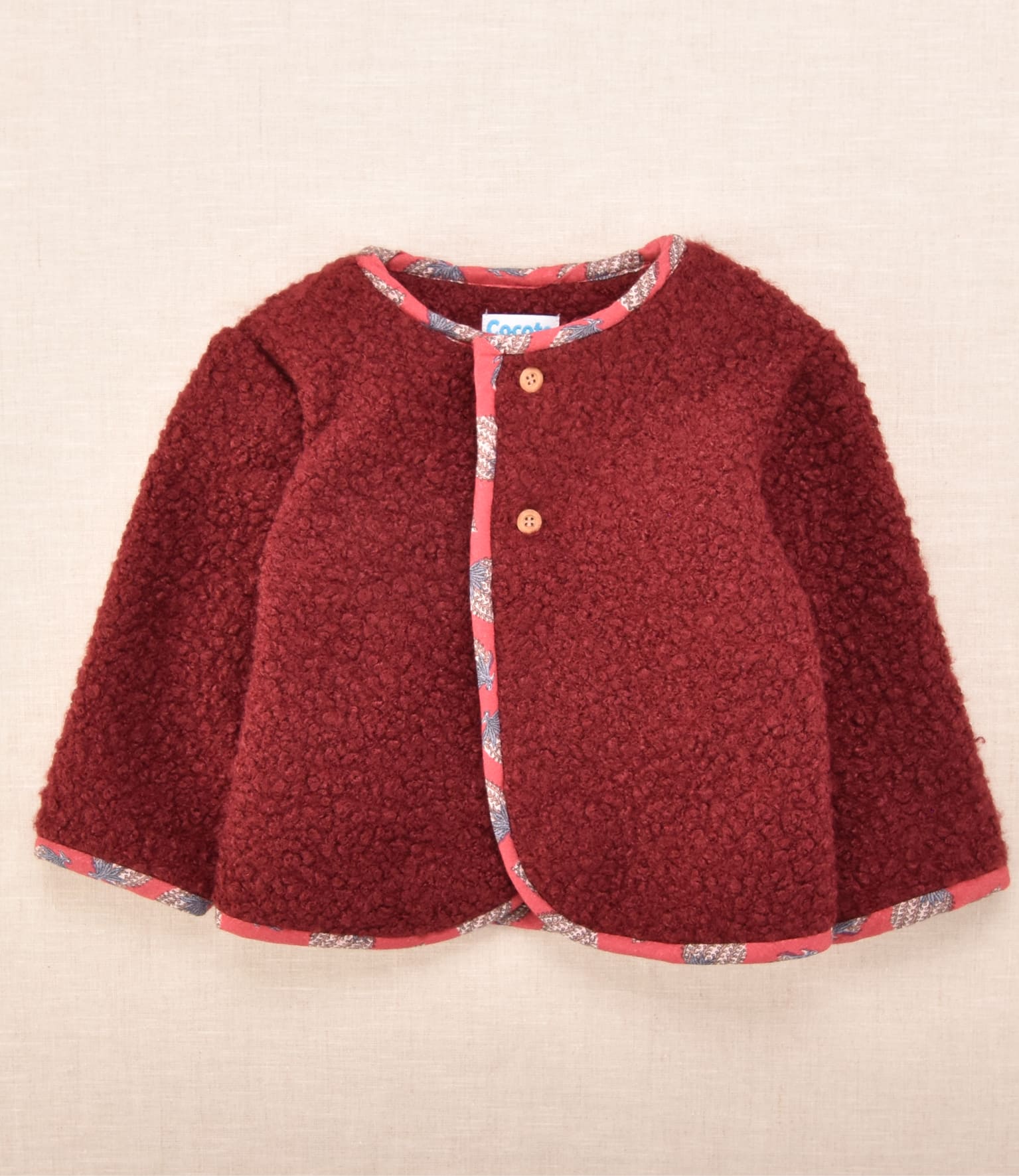 Chaqueta de bebé en tejido borreguito color burdeos con vivos estampados | Colección Cocote x Charanga