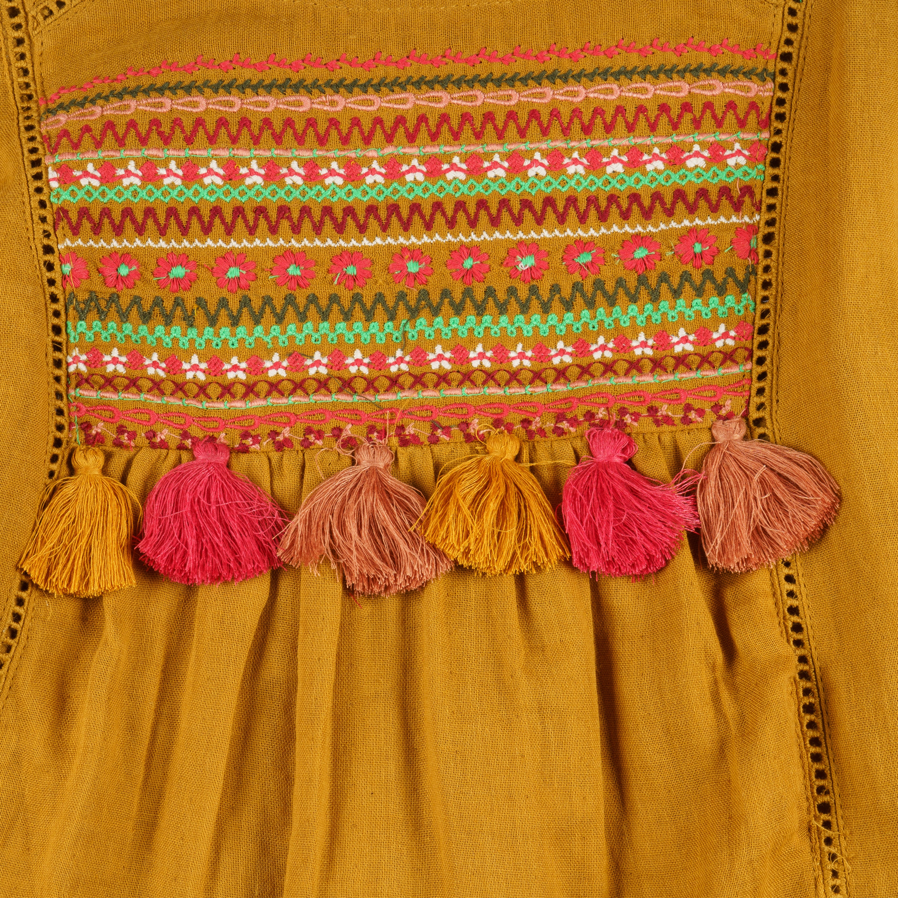 Vestido niña mostaza bambula bordado con borlas