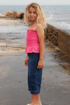 pantalón vaquero de niña azul en uso junto al mar