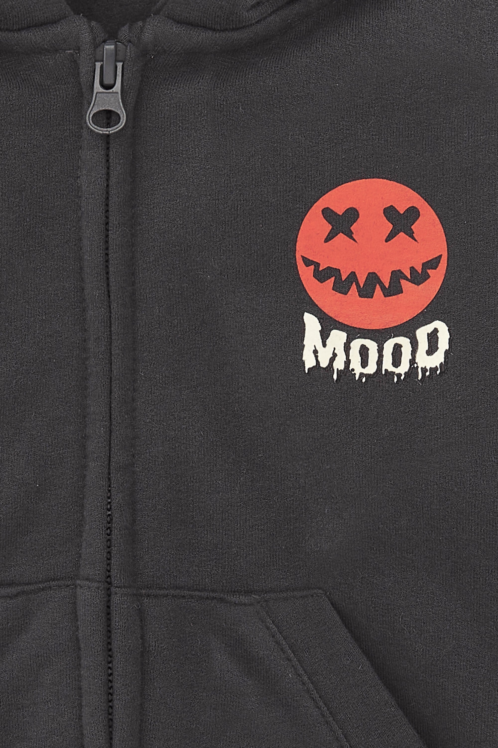 detalle cremallera y logo calabaza en sudadera antracita